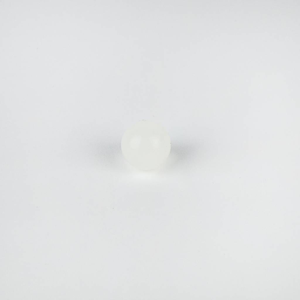 Das Bild zeigt eine kleine, durchsichtige, glatte Kugel, die auf einem weißen Hintergrund liegt. Sie könnte aus Kunststoff oder einem ähnlichen Material bestehen und eignet sich möglicherweise für experimentelle Zwecke im Bildungsbereich.