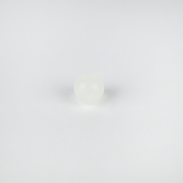 Das Bild zeigt eine kleine, durchsichtige, glatte Kugel, die auf einem weißen Hintergrund liegt. Sie könnte aus Kunststoff oder einem ähnlichen Material bestehen und eignet sich möglicherweise für experimentelle Zwecke im Bildungsbereich.