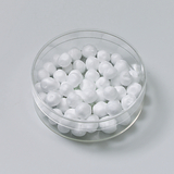 Das Bild zeigt eine durchsichtige Petri-Schale, die mit vielen kleinen weißen Kügelchen gefüllt ist. Diese Kügelchen sind vermutlich aus einem experimentellen Material, das für Bildungszwecke im deutschen Schulbereich verwendet wird.