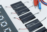 Das Bild zeigt mehrere solarbetriebene Module mit Kabeln, die zur Durchführung von Experimenten im Bildungsbereich verwendet werden können. Außerdem sind passende Verbindungskabel in verschiedenen Farben zu sehen, die für die Verbindung der Komponenten dienen.