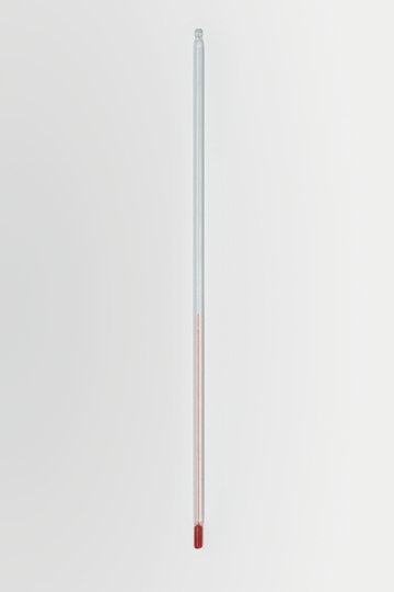 Das Bild zeigt ein transparentes Glasthermometer mit einer roten Flüssigkeit, die den Temperaturstand anzeigt. Es ist auf einem weißen Hintergrund platziert und eignet sich für Experimente im Bildungsbereich.