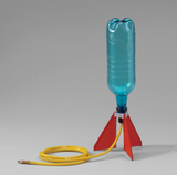 Das Bild zeigt eine kreative Rakete aus einer blauen PET-Flasche, die auf einem stabilen, rotem Ständer montiert ist. Ein gelber Schlauch ist angeschlossen, um zur Durchführung von Experimenten in der Schule oder im Bildungsbereich zu dienen.