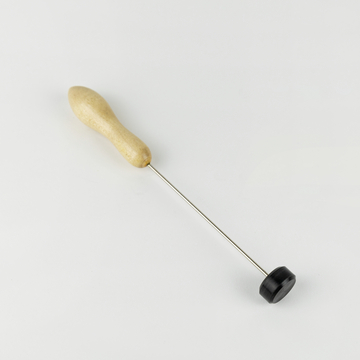 Das Bild zeigt ein Werkzeug mit einem Holzgriff und einem Metallstab, der an einem Ende eine schwarze, runde Fläche hat. Es handelt sich vermutlich um ein Gerät für Experimente oder handwerkliche Anwendungen im Bildungswesen.