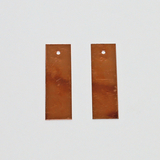 Das Bild zeigt zwei rechteckige Kupferplatten mit einem Loch an der oberen Kante. Diese Platten sind typischerweise für Experimente in der Elektrizitätslehre oder Chemie im Bildungsbereich geeignet.