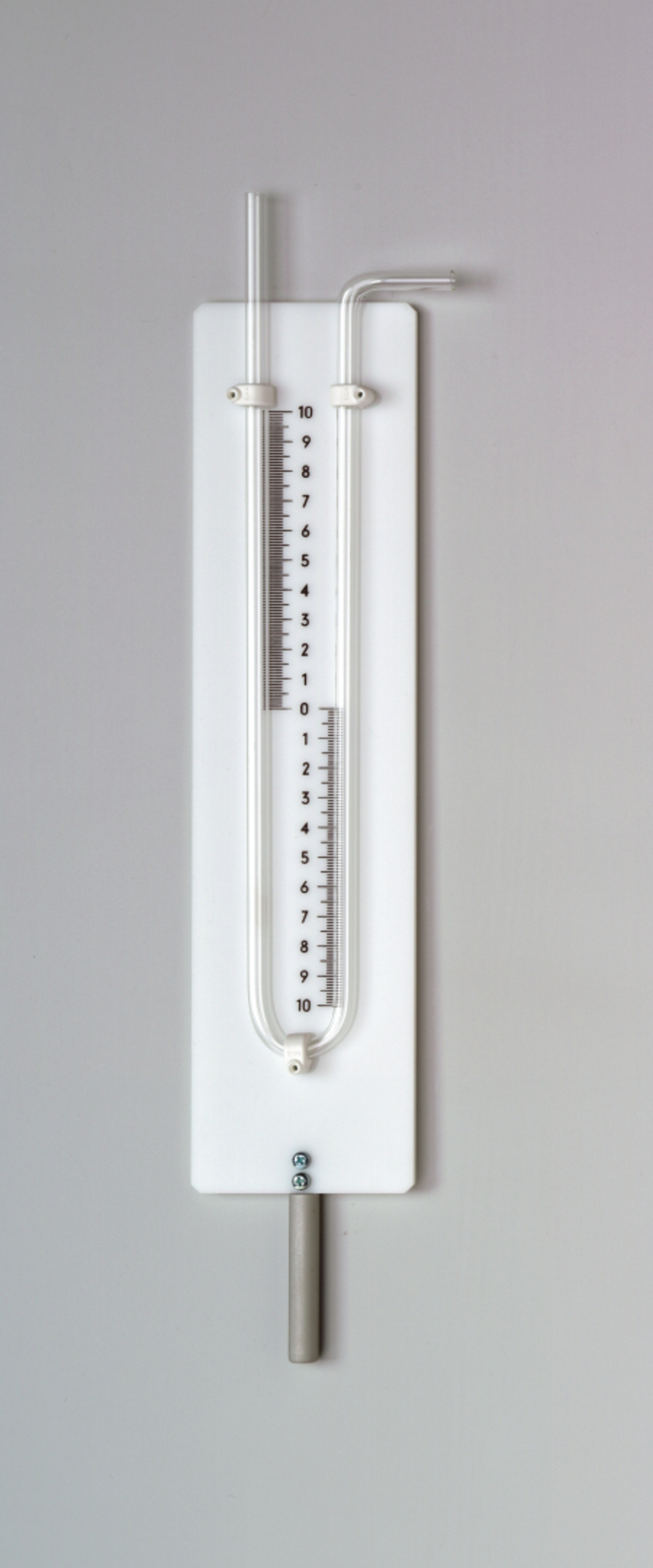 Das Bild zeigt ein Experimentiergerät, das zur Messung von Druck verwendet wird. Es besteht aus einer horizontalen Röhre mit einer Skala von 0 bis 10 und einem Metallgriff für die Bedienung.