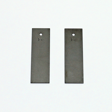 Das Bild zeigt zwei rechteckige Metallplatten, die aus Eisen (Fe) bestehen. Jede Platte ist mit einem Loch versehen, was auf ihre Verwendung in Experimenten oder in der Bildungsarbeit hinweist.