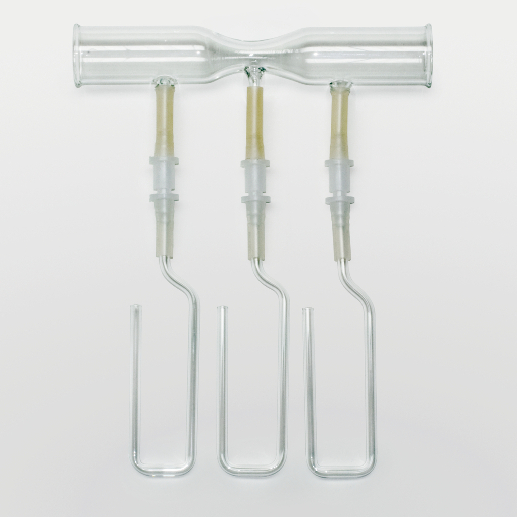 Das Bild zeigt ein gläsernes Experimentiergerät mit zwei verbundenen Röhren und drei Auslässen. Dieses Zubehör wird häufig für chemische Experimente in Bildungseinrichtungen eingesetzt.