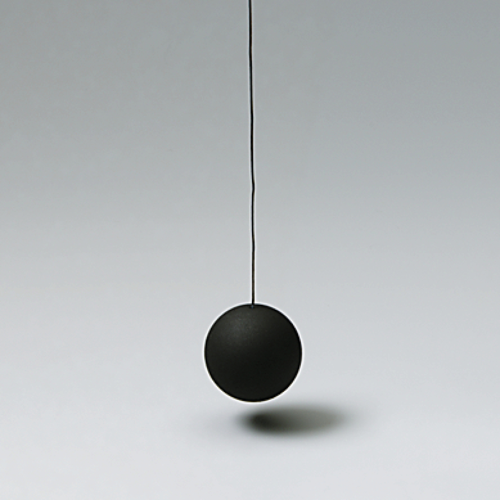 Das Bild zeigt eine schwarze Pendelkugel, die an einem dünnen Draht hängt. Der Hintergrund ist neutral und hebt das Exemplar deutlich hervor, was für Experimente im Bildungswesen geeignet ist.