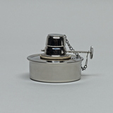 Das Bild zeigt einen Edelstahl-Brenner, der typischerweise in labortechnischen Experimenten verwendet wird. Er besitzt einen mittigen Docht und eine Schutzkappe, die mit einer Kette verbunden ist.