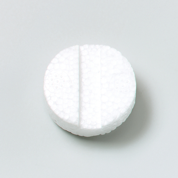 Das Bild zeigt eine runde, weiße Tablette mit einer geprägten Teilung in der Mitte. Die Oberfläche hat eine strukturierte, blasenartige Textur, die auf ihre spezielle Funktion im Experimentierbedarf hinweist.