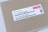 Das Bild zeigt eine braune Verpackung mit einem Etikett des Unternehmens Cornelsen. Der Inhalt des Schüler-Sets befasst sich mit Elektrizität, insbesondere Induktion und Wechselspannung, und dient als Erweiterung für Experimentierzwecke im Bildungswesen.