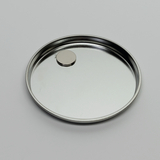 Auf dem Bild ist eine runde, flache Metallschale zu sehen, in deren Mitte sich ein kleiner kreisförmiger Magnet befindet. Die Oberfläche der Schale ist glänzend und reflektiert das Licht.