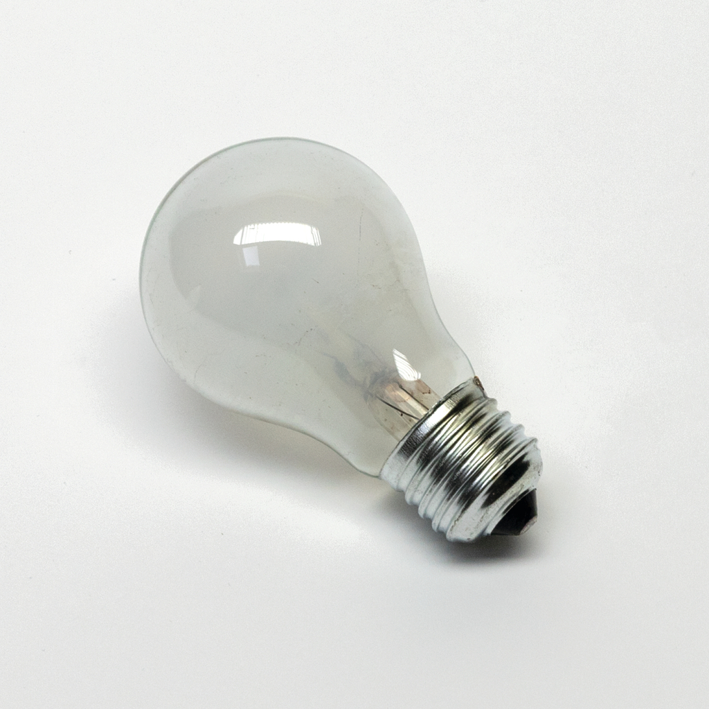 Das Bild zeigt eine transparente Glühbirne mit einem geschliffenen Metallgewinde. Sie wird häufig in Experimenten zur Demonstration von Elektrizität und Licht eingesetzt.