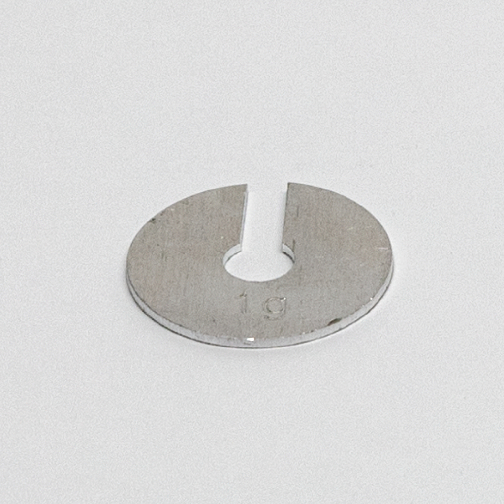 Das Bild zeigt ein metallisches Experimentiergerät in Form einer runden Scheibe mit einem Einschnitt und einer zentralen Bohrung. Die Zahl „19“ ist eingraviert, was möglicherweise auf eine spezifische Größe oder Art des Zubehörs hinweist.