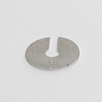 Das Bild zeigt ein metallisches Experimentiergerät in Form einer runden Scheibe mit einem Einschnitt und einer zentralen Bohrung. Die Zahl „19“ ist eingraviert, was möglicherweise auf eine spezifische Größe oder Art des Zubehörs hinweist.
