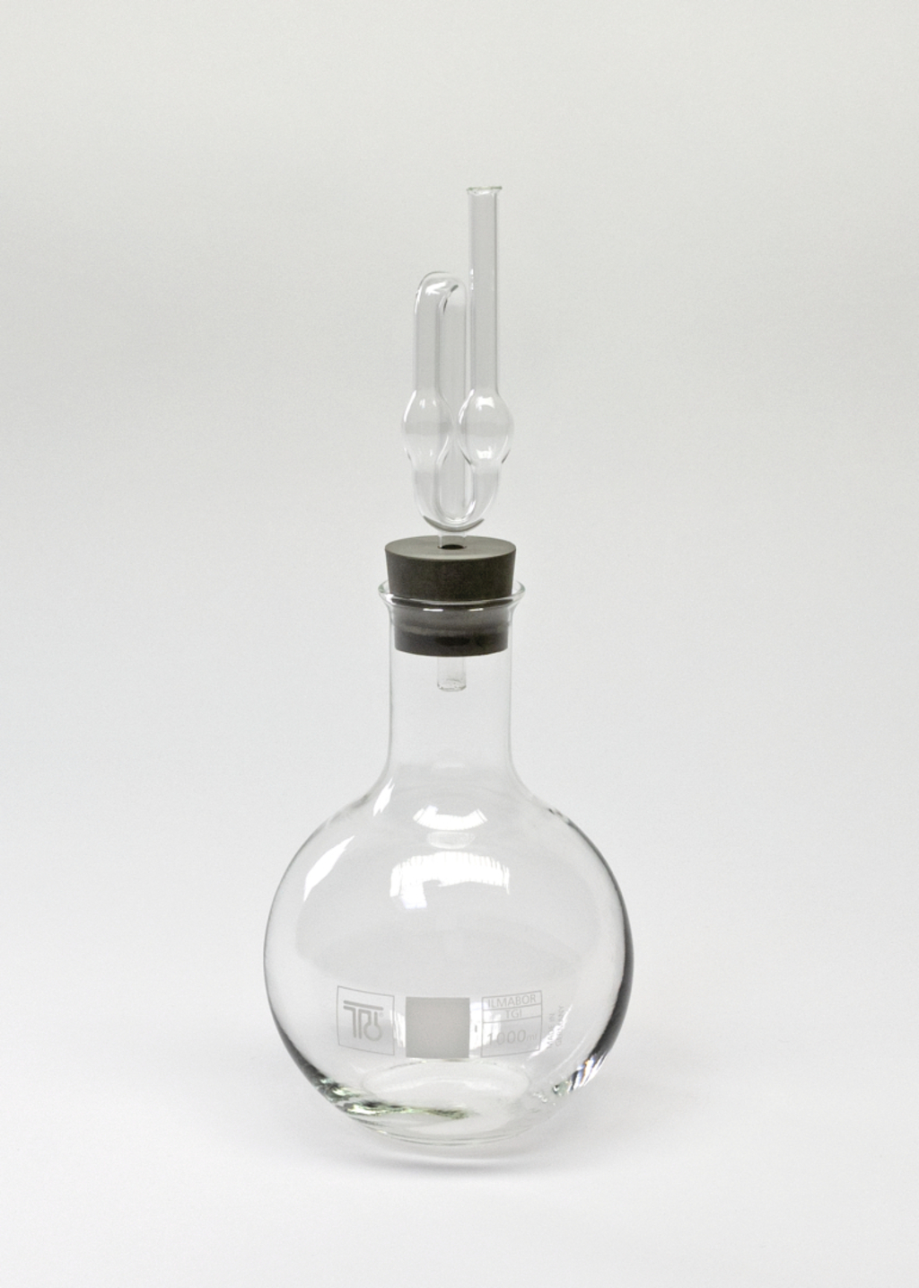 Das Bild zeigt ein chemisches Glasgerät, genauer gesagt einen Rundkolben mit einem eingebauten Stopfen und einem Glasrohr. Dieses Laborglasgerät wird häufig in Experimenten zur Durchführung von chemischen Reaktionen verwendet.