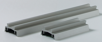 Das Bild zeigt mehrere graue Profile, die aus einem leichten, stabilen Material gefertigt sind. Sie sind in unterschiedlichen Längen und Breiten angeordnet und dienen vermutlich als Experimentiermaterial für den Bildungsbereich.