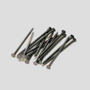 Das Bild zeigt eine Ansammlung von metallischen Nägeln, die auf einer neutralen Oberfläche liegen. Diese Nägel könnten für verschiedene Experimente oder Bauprojekte im Bildungsbereich verwendet werden.