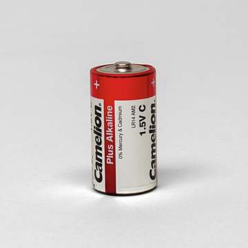 Das Bild zeigt eine C-Batterie der Marke Camelion in roter Verpackung. Sie ist als alkalische Batterie mit einer Spannung von 1,5 V gekennzeichnet und enthält keine Quecksilber- oder Cadmiumbestandteile.
