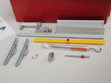 Das Bild zeigt eine Sammlung von Experimentierzubehör, darunter Halterungen, ein Messzylinder, eine Federwaage und verschiedene Stäbe und Clips. Diese Komponenten sind für den Einsatz in schulischen Experimenten und wissenschaftlichen Untersuchungen gedacht.