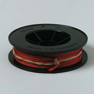 Das Bild zeigt eine Spule mit rot gefärbtem Draht, die auf einem schwarzen Kunststoffkörper gewickelt ist. Der Draht ist zur Verwendung in Experimenten im Bildungsbereich geeignet und stammt aus Westeuropa.