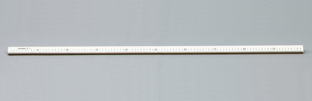 Das Bild zeigt ein gerades Lineal, das auf einer grauen Unterlage liegt. Es ist in Zentimetern und Millimetern skaliert und dient als präzises Messwerkzeug für experimentelle Zwecke im Bildungsbereich.