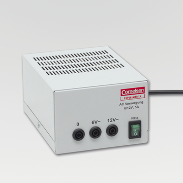 Das Bild zeigt ein weißes Netzgerät mit einem Lüftungsgitter und drei Anschlüssen für Spannungen von 0, 6V und 12V. Es ist ein Produkt der Marke Cornelsen, das für den experimentellen Einsatz im Bildungswesen konzipiert ist.