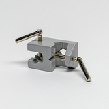 Das Bild zeigt einen grauen Experimentierklemmenhalter, der zur Befestigung von Materialien in wissenschaftlichen Experimenten verwendet wird. Er verfügt über Schrauben, um die Spannung einzustellen, und lässt sich somit leicht an verschiedene Objekte anpassen.