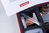 Das Bild zeigt einen Experimentierkasten mit verschiedenen Komponenten, darunter ein transparentes Röhrchen und Kupferdraht, in einem gepolsterten Fach. Darüber liegt ein Dokument mit dem Logo von Cornelsen, was auf den Anbieter des Materials hinweist.
