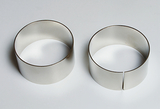 Das Bild zeigt zwei metallene Ringe, die für Experimente verwendet werden können. Der linke Ring ist vollständig, während der rechte Ring eine ausgeschnittene Öffnung hat, was unterschiedliche Einsatzmöglichkeiten bei Experimenten ermöglicht.