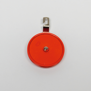 Das Bild zeigt eine runde, rot lackierte Messskala mit einem silbernen Haken. Sie dient wahrscheinlich für experimentelle Zwecke, um präzise Messungen in einem Bildungsumfeld durchzuführen.
