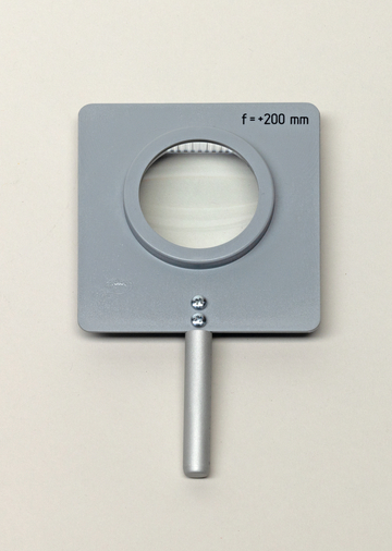Das Bild zeigt eine große Lupe mit einer rechteckigen grauen Halterung und einem breiten Griff. Die Linse hat eine Brennweite von +200 mm und dient zur Vergrößerung von Objekten für experimentelle Zwecke im Bildungsbereich.