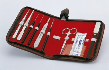 Das Bild zeigt ein Set von Werkzeugen, die in einem roten Etui organisiert sind. Die enthaltenen Instrumente umfassen verschiedene Skalpelle, Pinzetten, eine Schere und Zubehör, das für Experimente im Bildungsbereich nützlich ist.