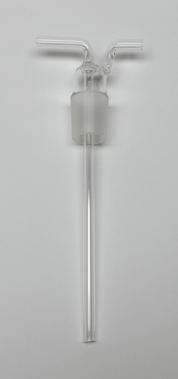 Das Bild zeigt ein Glasgerät mit zwei kurzen Auslässen und einem langen Rohr, das typischerweise in chemischen Experimenten verwendet wird. Es ist transparent und hat eine matte Halterung, die es ermöglicht, es sicher mit anderen Laborgeräten zu verbinden.
