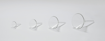 Das Bild zeigt eine Reihe von vier transparenten Trichtern in unterschiedlichen Größen, angeordnet von klein nach groß. Die Trichter bestehen aus klarem Material und haben einen schmalen Auslauf, ideal für die Verwendung in Experimenten oder in der Chemieausbildung.