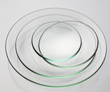 Das Bild zeigt eine Reihe von klaren, runden Glasplatten in verschiedenen Größen, die übereinander gestapelt sind. Diese Platten können für verschiedene Experimente und wissenschaftliche Anwendungen im Bildungswesen verwendet werden.