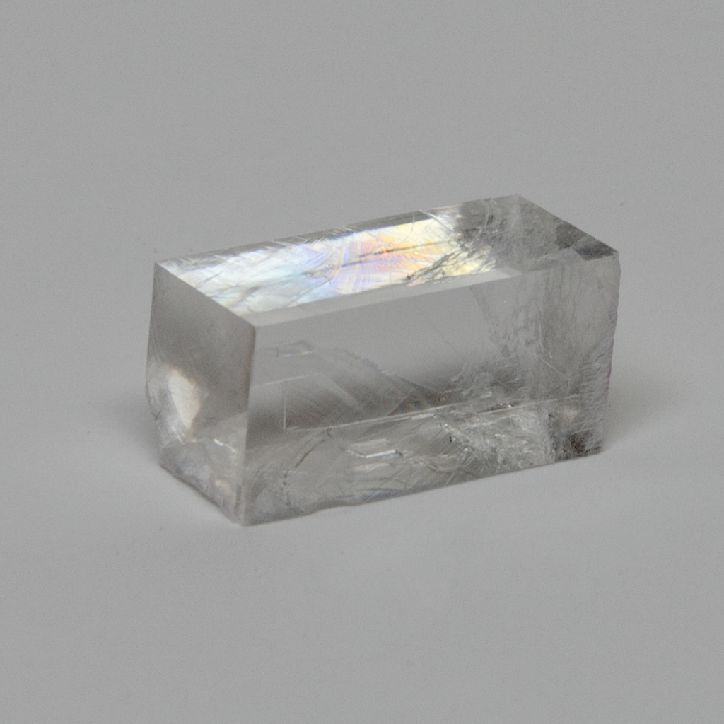 Das Bild zeigt einen klaren, prismatischen Kristall, der durch seine glatte Oberfläche und die Lichtreflexionen besticht. Er eignet sich ideal für Experimente zur Lichtbrechung und zur Untersuchung optischer Phänomene im Bildungsbereich.