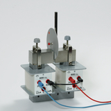 Das Bild zeigt ein Experimentiergerät mit zwei Spulen, die mit verschiedenen Widerständen ausgestattet sind. Es dient der Demonstration elektromagnetischer Prinzipien und der Analyse elektrischer Schaltungen im Bildungsbereich.