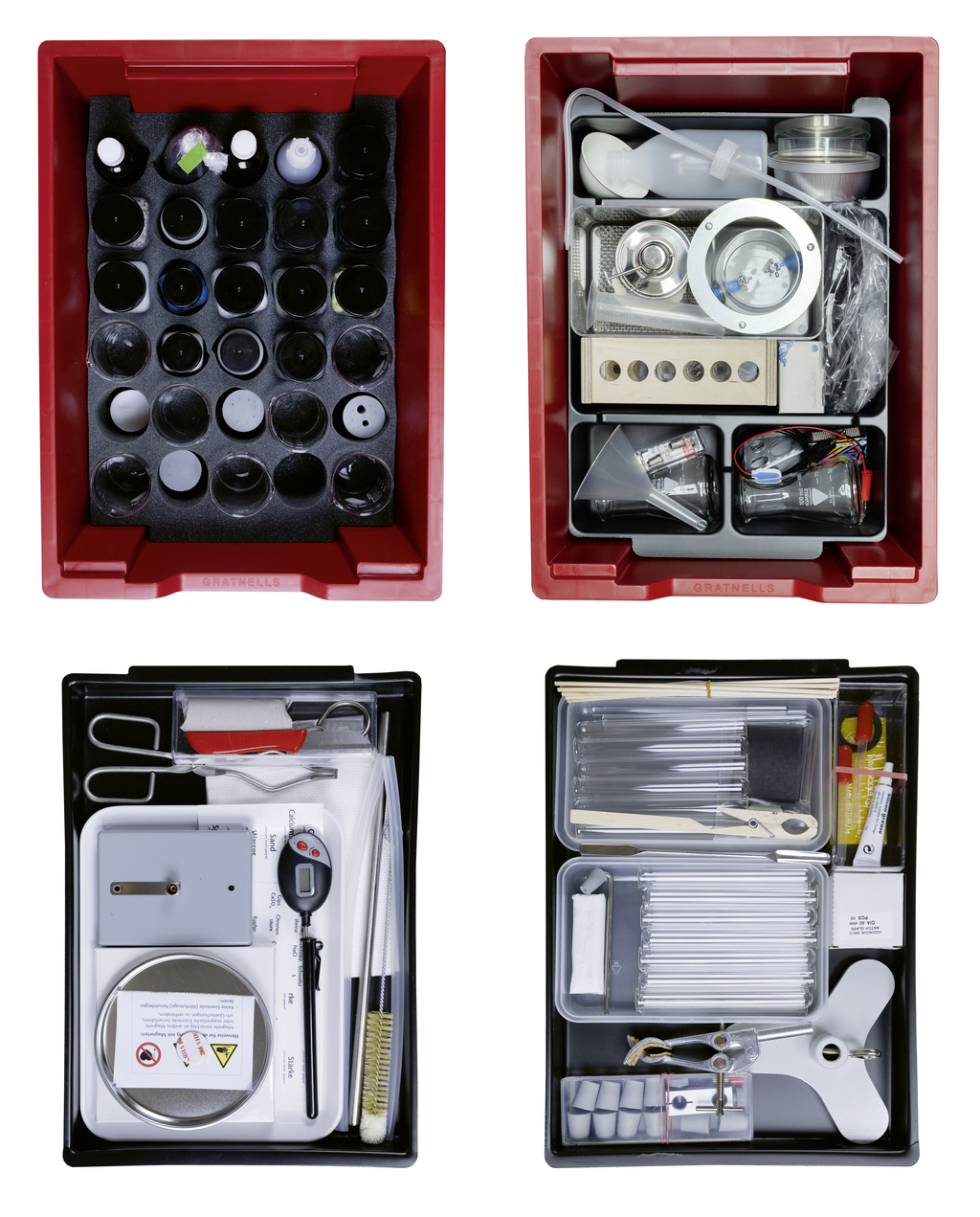 Das Bild zeigt vier Boxen mit Experimentiermaterialien, die für Bildungszwecke im deutschen Schulsystem konzipiert sind. Die Boxen enthalten verschiedene chemische Gläser, Geräte und Zubehör, um Schülern praktische Experimente zu ermöglichen.