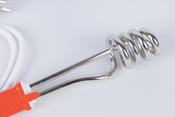 Zu sehen ist ein elektrischer Heizstab mit einer spiralförmigen Metallspirale, der zum Erhitzen von Flüssigkeiten eingesetzt wird. Der Heizstab ist an einem roten Stecker mit einem weißen Kabel verbunden, das für den Betrieb erforderlich ist.