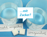 Zwei durchsichtige Becher mit Wasser sind auf einem blauen Untergrund platziert. Einer der Becher ist beschriftet mit "nicht umgerührt" und der andere mit "umgerührt", während zwei Würfelzucker in der Mitte liegen und eine Sprechblase mit der Frage "...mit Zucker?" erscheint.