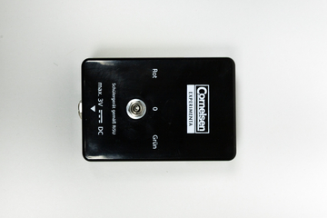 Ein schwarzes Experimentiergerät zeigt eine Anschlussbuchse sowie farbige Beschriftungen in Rot und Grün. Es ist für den Gebrauch in der Schule konzipiert und unterstützt eine maximale Spannung von 3 Volt Gleichstrom.