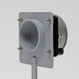 Ein graues Gerät mit einem runden Öffnungsgitter und mehreren Halterungen befindet sich auf einem stabilen Standfuß. Es scheint für experimentelle Zwecke im Bildungsbereich konzipiert zu sein, um möglicherweise Luftströmungen oder ähnliche Phänomene zu demonstrieren.