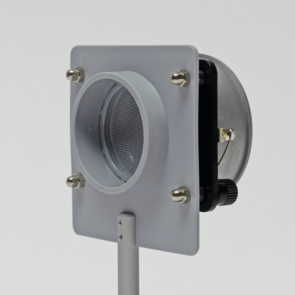 Ein graues Gerät mit einem runden Öffnungsgitter und mehreren Halterungen befindet sich auf einem stabilen Standfuß. Es scheint für experimentelle Zwecke im Bildungsbereich konzipiert zu sein, um möglicherweise Luftströmungen oder ähnliche Phänomene zu demonstrieren.