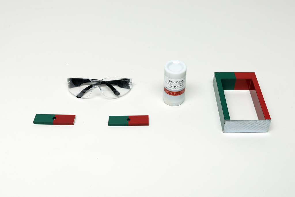 Ein Set für Magnetexperimente enthält zwei Stabmagnete, einen Hufeisenmagneten und Eisenpulver. Ergänzt wird die Ausstattung durch eine Schutzbrille.