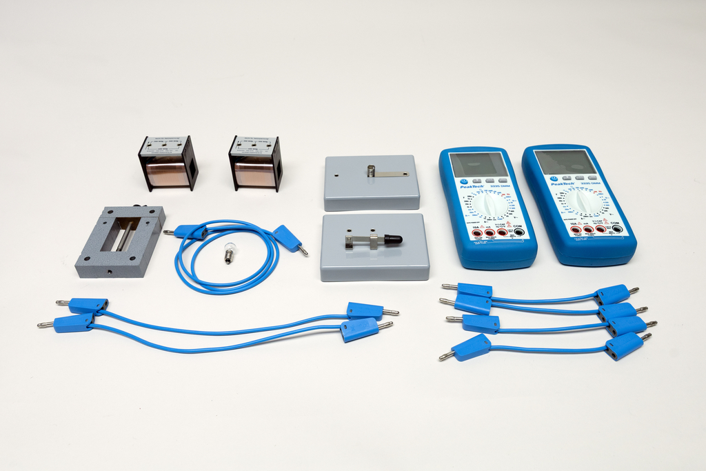 Ein Set aus Physik-Experimentierbedarf umfasst zwei Multimeter, verschiedene elektrische Bauteile und blaue Verbindungskabel. Die Komponenten sind ordentlich auf einem weißen Hintergrund angeordnet.