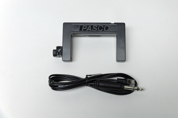 Ein schwarzes PASCO-Messgerät in U-Form liegt auf einem weißen Hintergrund. Darunter befindet sich ein zusammengerolltes schwarzes Verbindungskabel.