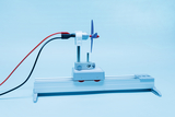 Ein kleiner Elektromotor mit blauem Propeller ist auf einem Aluminiumprofil montiert. Rote und schwarze Kabel führen zur Stromversorgung des Versuchsaufbaus.