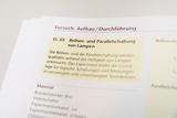 Eine Anleitung beschreibt den Versuchsaufbau zur Reihen- und Parallelschaltung von Lampen. Darunter ist eine Materialliste mit Brückensteckern, Hebelschaltern und Kabeln aufgeführt.