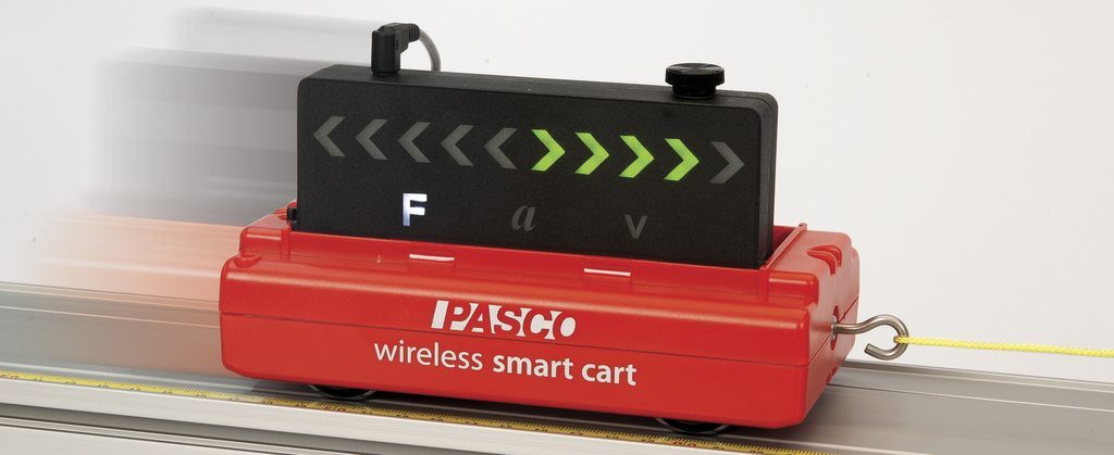 Ein roter PASCO Wireless Smart Cart fährt auf einer Metallschiene. Auf dem Wagen befindet sich ein schwarzes Display, das physikalische Größen wie Kraft, Beschleunigung und Geschwindigkeit anzeigt.